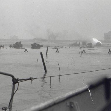Vue prise depuis le LCT 610. Sword Beach, secteur Queen Red, vers 8h00. Un char du 22e Dragon brule après avoir été touché par un tir allemand.