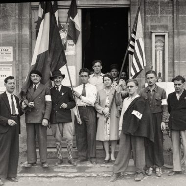4 juillet 1944.Le jour de la fête nationale américaine, des habitants de Trévières posent avec des drapeaux français et américain.