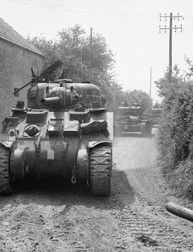 Les blindés britanniques – un Sherman suivi de chars Cromwell - prennent positions dans les environs de Tilly-sur-Seulles.