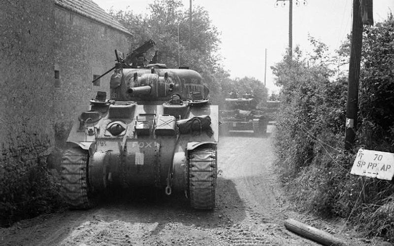 Les blindés britanniques – un Sherman suivi de chars Cromwell - prennent positions dans les environs de Tilly-sur-Seulles.